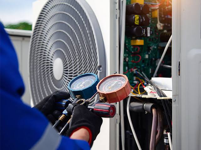 Technician using gauges to diagnose heat-pump equipment