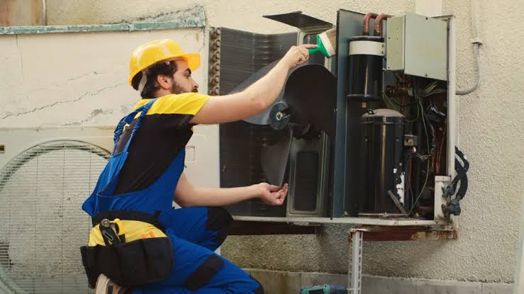 Technician performing preventive maintenance inside an HVAC unit