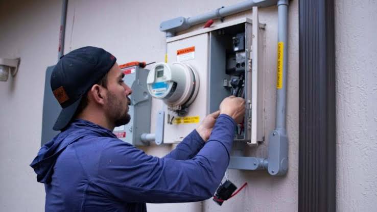 Technician checking an outdoor electrical service panel