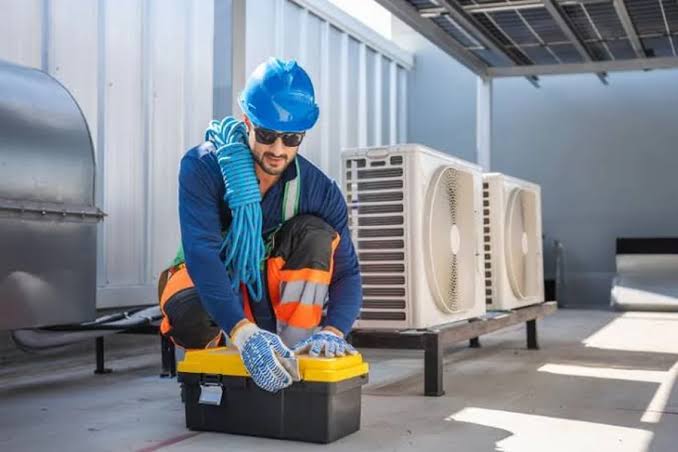 HVAC technician preparing tools near commercial cooling equipment